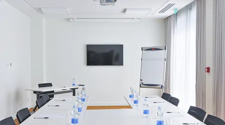 Salle d’OSKO en configuration réunion avec écran mural