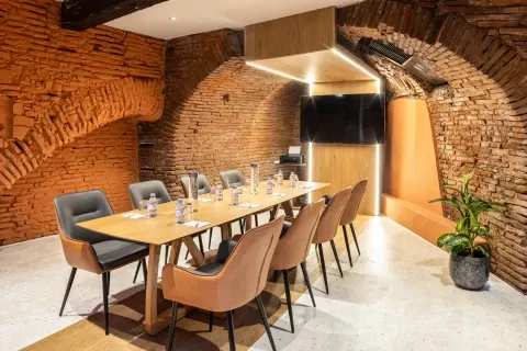 Table en bois sous les voûtes de briques d’OVYO, à Toulouse